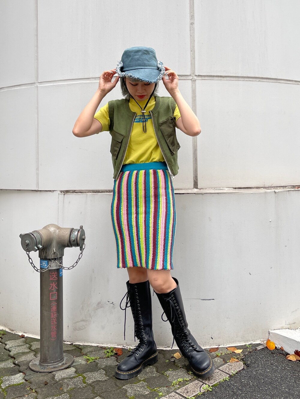 イエロー系のTシャツ/カットソー、グリーン系のベスト、ブルー系のスカートを着用したレディースの春コーディネートの5枚目の写真