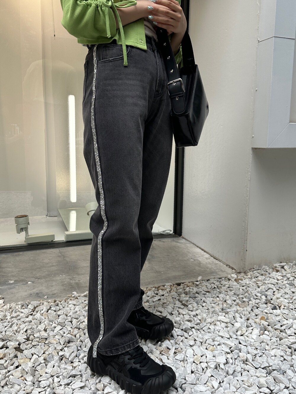 グリーン系のTシャツ/カットソー、ブラック系のデニムパンツ、ブラック系のハンドバッグを着用したレディースの夏コーディネートの8枚目の写真