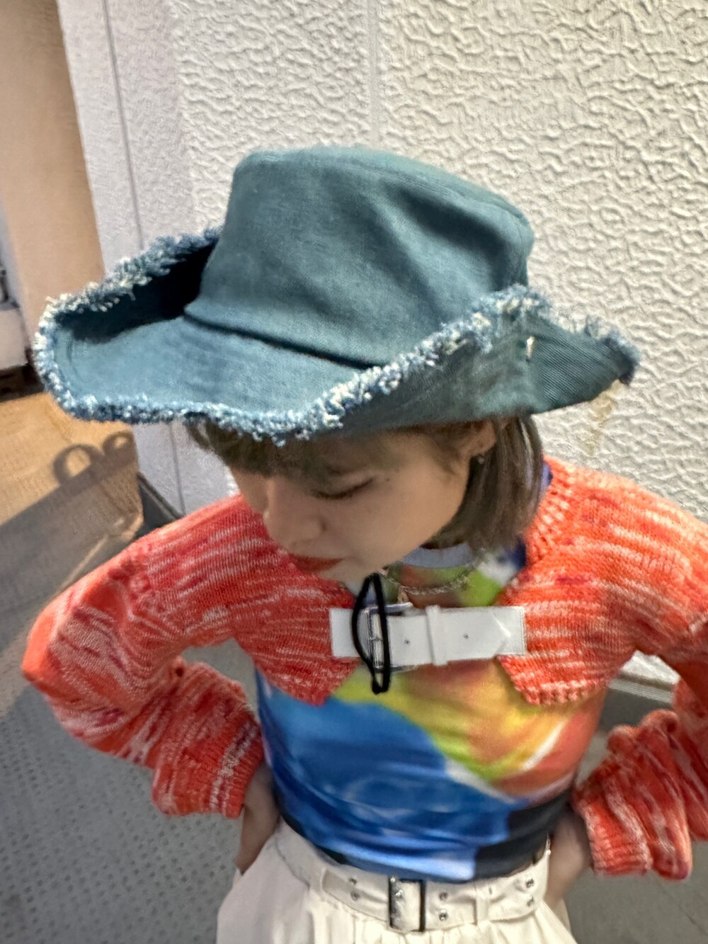 イエロー系のその他パンツ、オレンジ系のニット/セーター、ブラック系のTシャツ/カットソーを着用したレディースの冬コーディネートの7枚目の写真