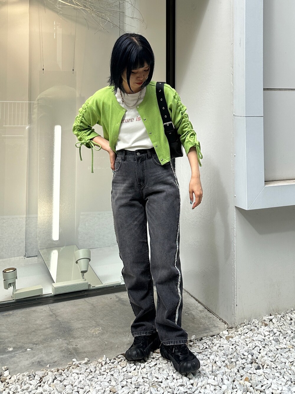 グリーン系のTシャツ/カットソー、ブラック系のデニムパンツ、ブラック系のハンドバッグを着用したレディースの夏コーディネートの2枚目の写真