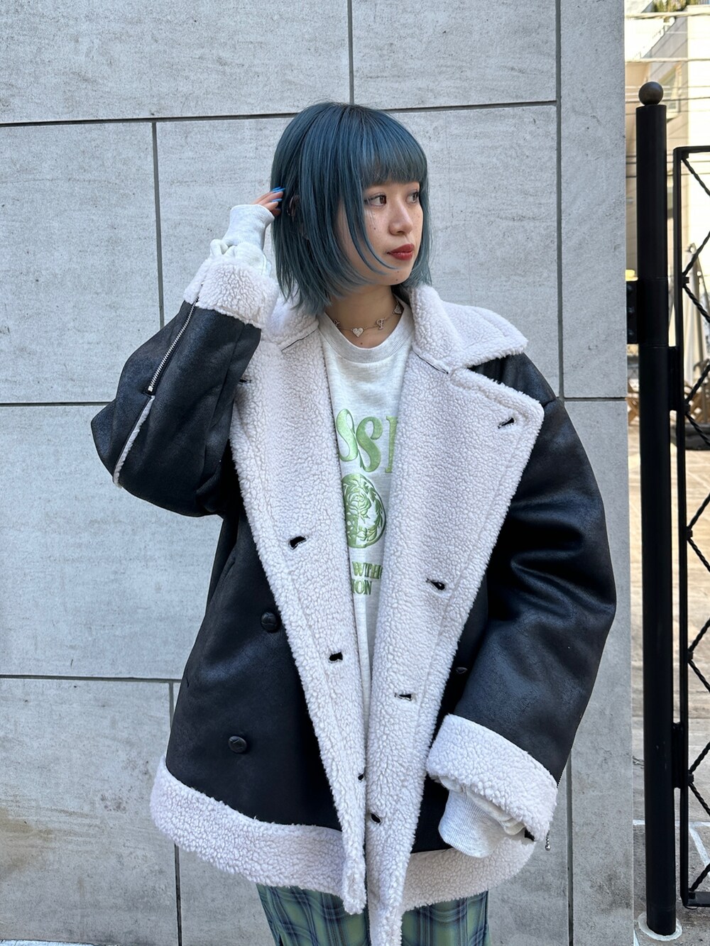 ブラック系のムートンコート、グレー系のスウェット、グリーン系のワンピースを着用したレディースの冬コーディネートの5枚目の写真