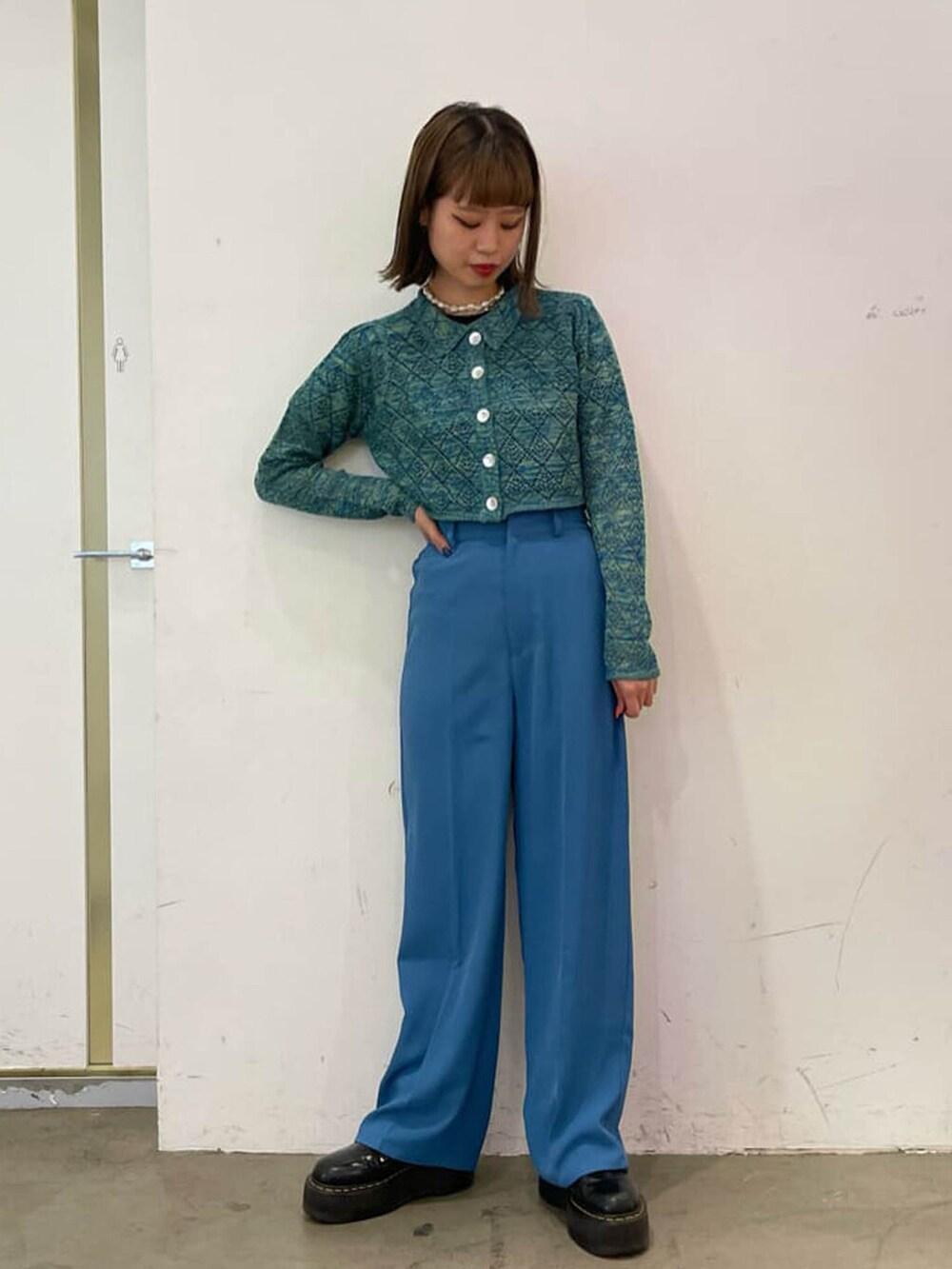 ブルー系のスラックス、グリーン系のシャツ/ブラウス、シルバー系のチョーカーを着用したレディースの冬コーディネートの2枚目の写真