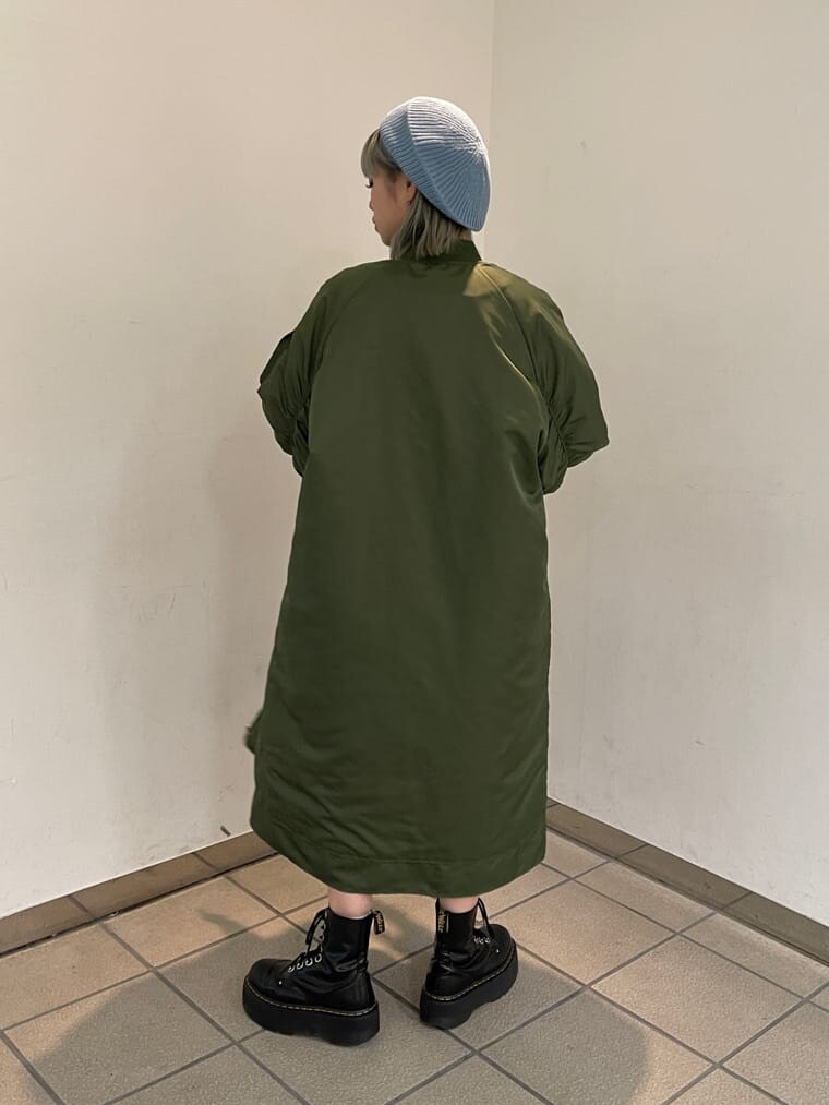 ブラック系のニット/セーター、グリーン系のMA-1、グリーン系のスカートを着用したレディースの秋コーディネートの4枚目の写真