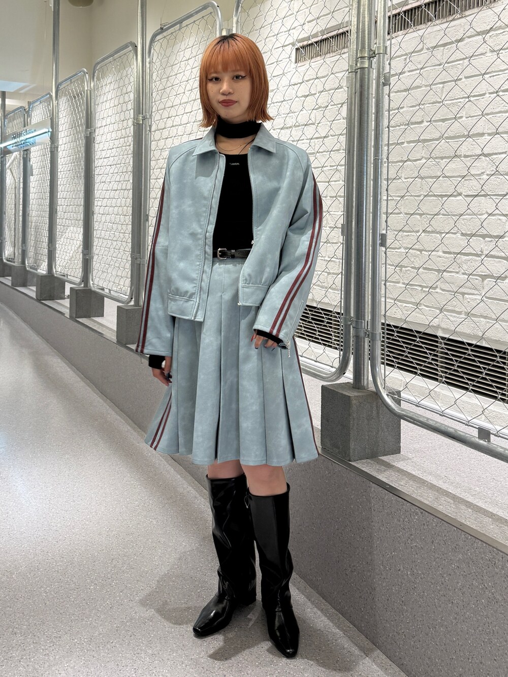 ブルー系のブルゾン、ブルー系のスカート、ブラック系のニット/セーターを着用したレディースの冬コーディネートの5枚目の写真