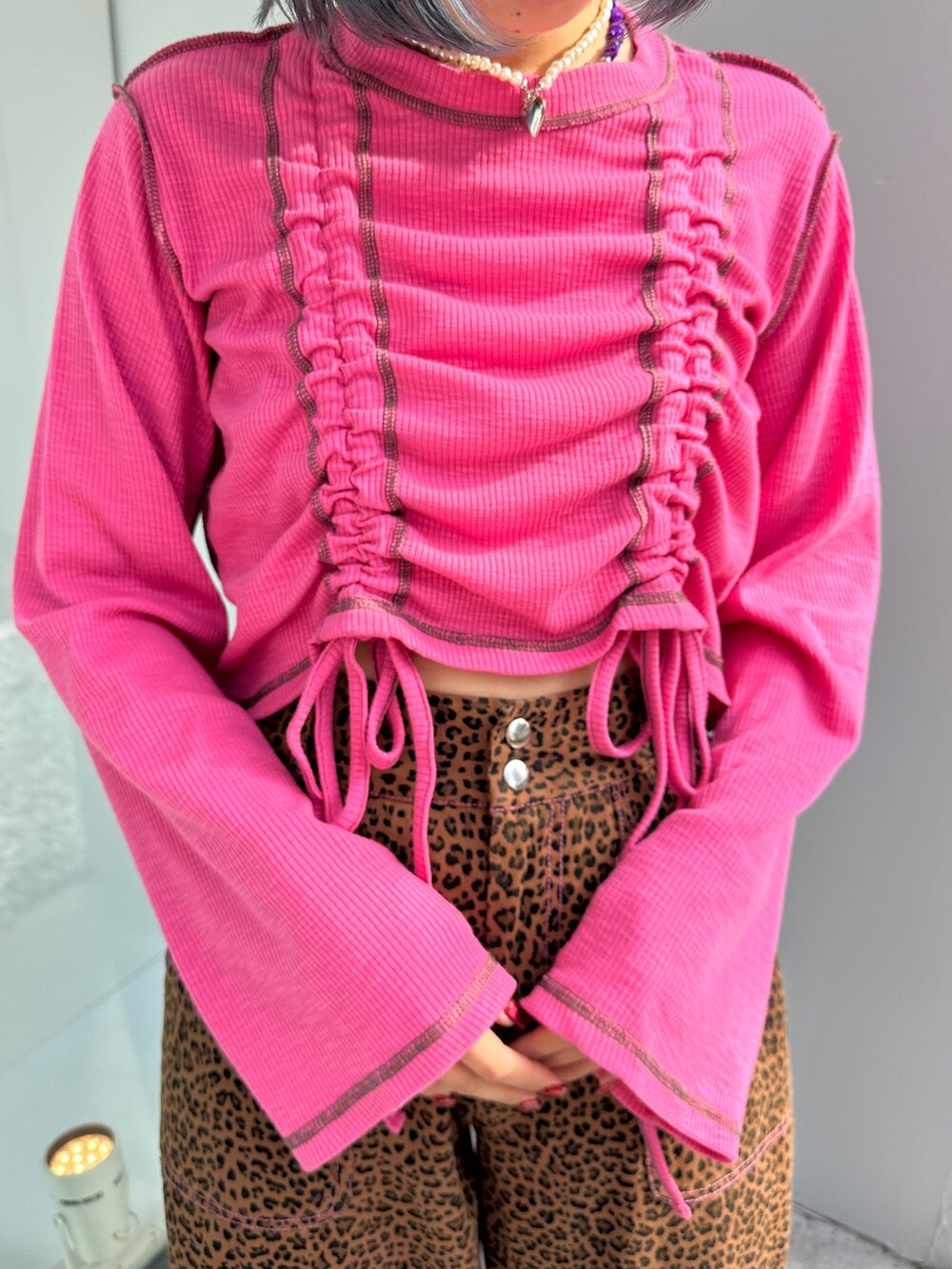 ピンク系のTシャツ/カットソー、ベージュ系のその他パンツ、ブラック系のその他シューズを着用したレディースの春コーディネートの7枚目の写真