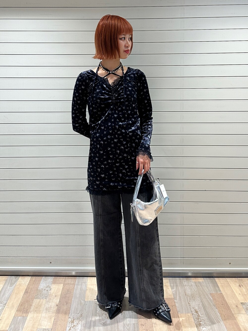 ブルー系のワンピース、シルバー系のハンドバッグ、ブラック系のデニムパンツを着用したレディースの冬コーディネートの2枚目の写真