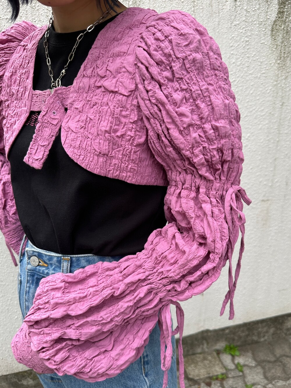 ピンク系のカーディガン/ボレロ、ブラック系のTシャツ/カットソー、ブルー系のデニムパンツを着用したレディースの春コーディネートの7枚目の写真