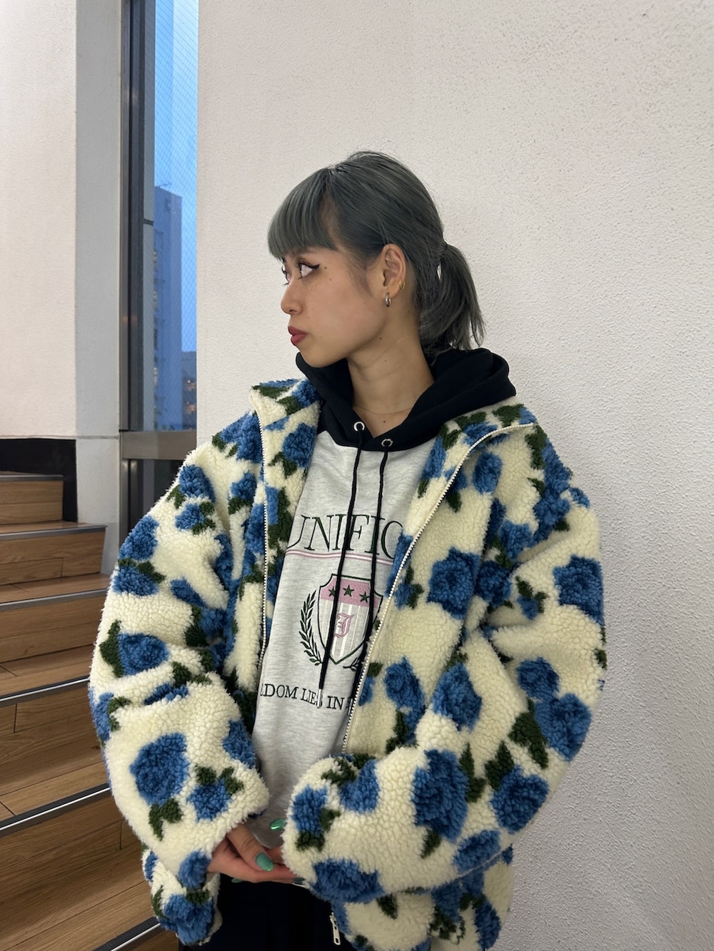 ホワイト系のブルゾン、グレー系のパーカー、ブラック系のその他パンツを着用したレディースの秋コーディネートの3枚目の写真
