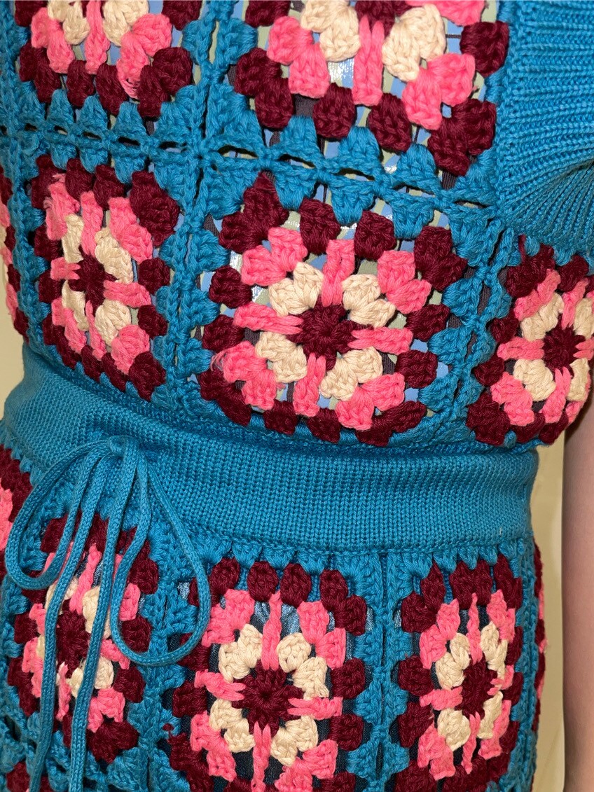 ブラック系のブーツ、ブルー系のスカート、ブルー系のベストを着用したレディースの春コーディネートの4枚目の写真