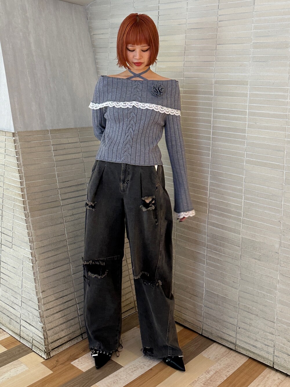 グレー系のニット/セーター、ブラック系のデニムパンツ、ブラック系のブーツを着用したレディースの冬コーディネートの2枚目の写真