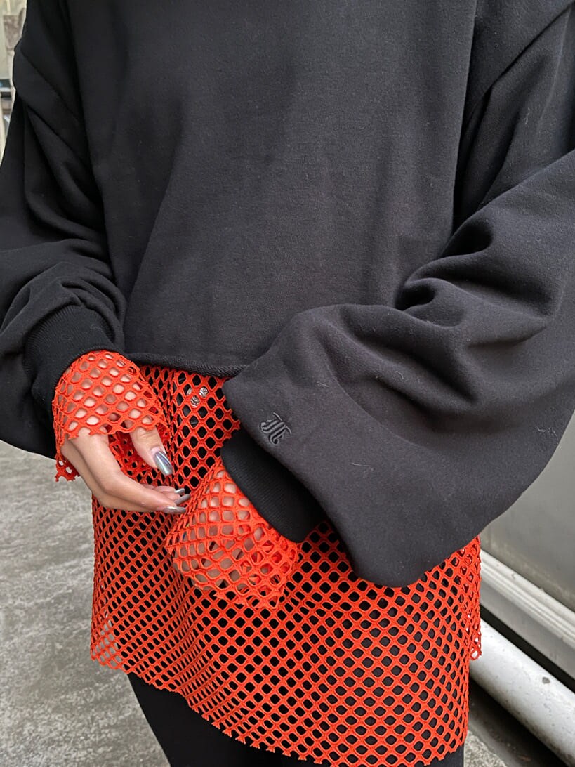 ブラック系のブーツ、ブラック系のTシャツ/カットソー、オレンジ系のTシャツ/カットソーを着用したレディースの冬コーディネートの9枚目の写真