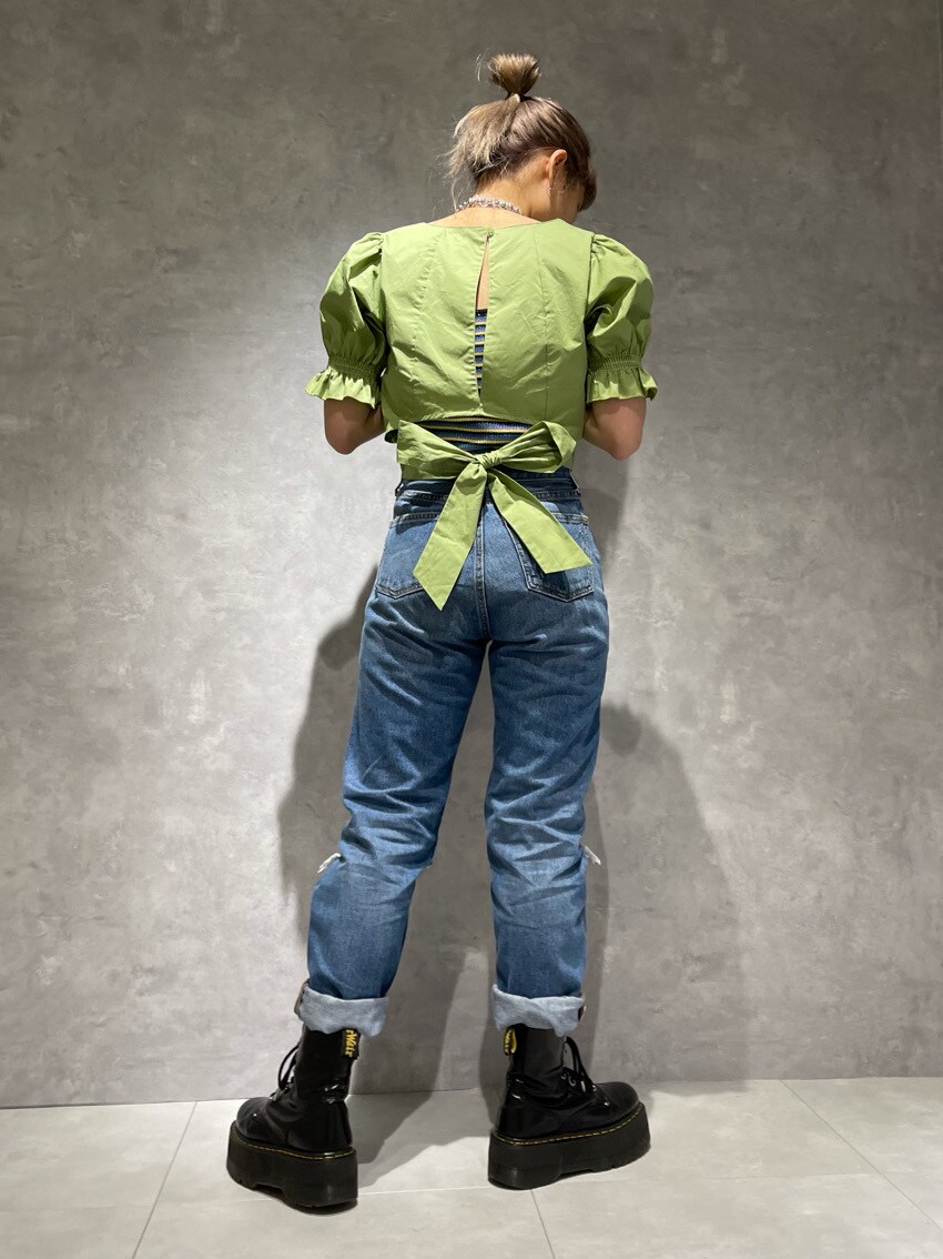 グリーン系のシャツ/ブラウス、ブラック系のキャミソール、ブルー系のデニムパンツを着用したレディースの春コーディネートの2枚目の写真