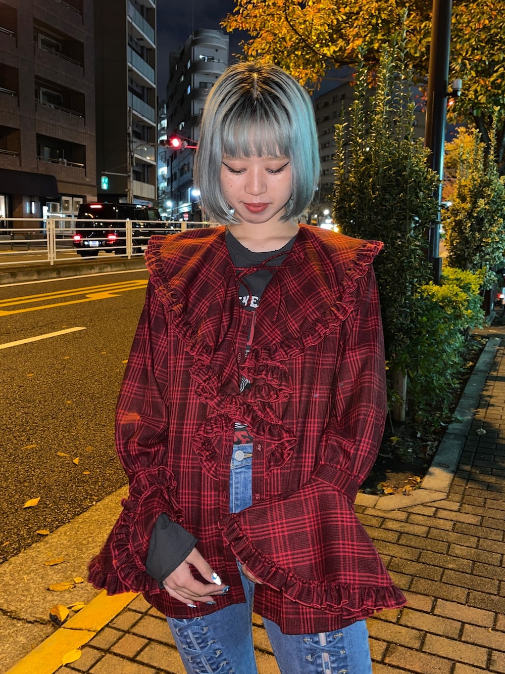 レッド系のシャツ/ブラウス、ブラック系のTシャツ/カットソー、ブルー系のデニムパンツを着用したレディースの秋コーディネートの4枚目の写真