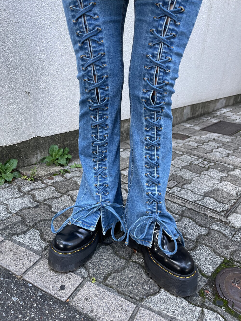 ブラック系のスタジャン、ホワイト系のニット/セーター、ブルー系のデニムパンツを着用したレディースの秋コーディネートの10枚目の写真