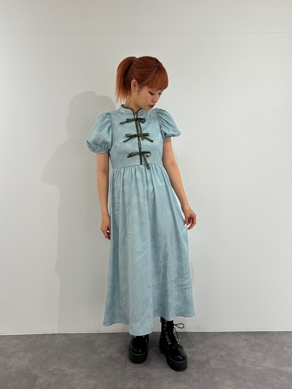 ブルー系のワンピース、ブラック系のブーツを着用したレディースの春コーディネートの2枚目の写真