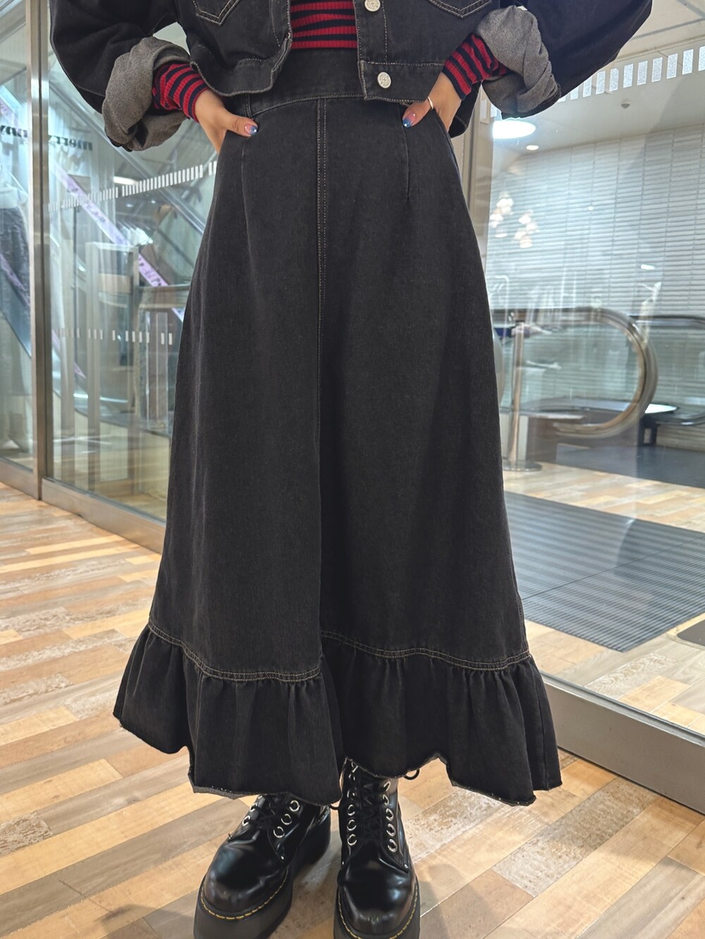 レッド系のTシャツ/カットソー、ブラック系のワンピース、ブラック系のブーツを着用したレディースの夏コーディネートの8枚目の写真