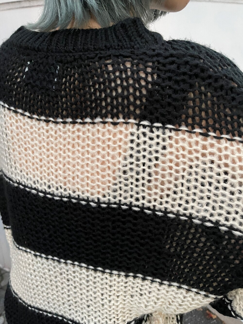 ブラウン系のスカート、ブラック系のニット/セーター、ブラック系のスニーカーを着用したレディースの秋コーディネートの9枚目の写真