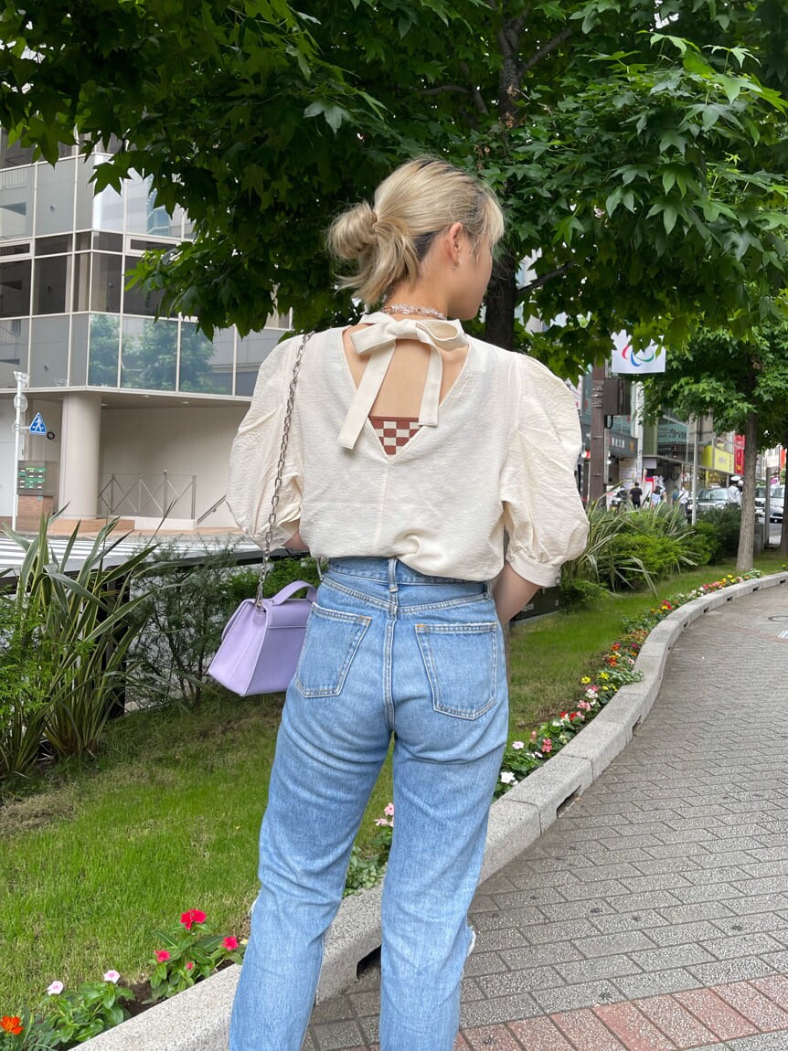 パープル系のショルダーバッグ、ホワイト系のシャツ/ブラウス、ブルー系のデニムパンツを着用したレディースの夏コーディネートの5枚目の写真