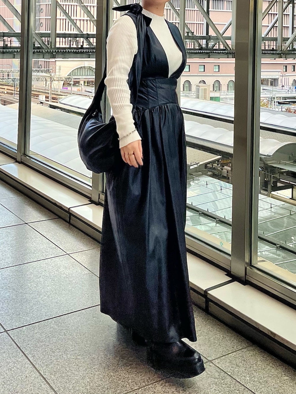 グレー系のノーカラージャケット、ブラック系のジャンパースカート、ホワイト系のニット/セーターを着用したレディースの秋コーディネートの5枚目の写真