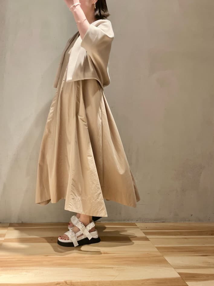 ホワイト系のサンダル、ベージュ系のブルゾン、ベージュ系のワンピースを着用したレディースの春コーディネートの5枚目の写真