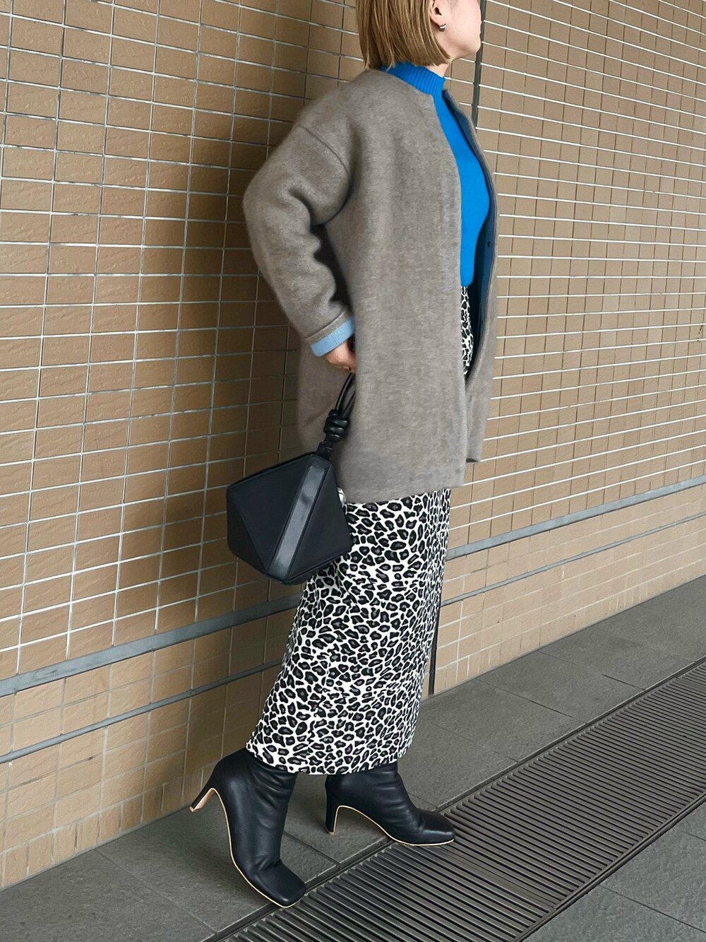 ベージュ系のノーカラージャケット、ブラック系のブーツ、ブラック系のハンドバッグを着用したレディースの夏コーディネートの3枚目の写真