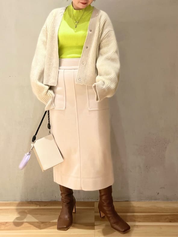 ブラウン系のブーツ、ベージュ系のショルダーバッグ、グリーン系のニット/セーターを着用したレディースの秋コーディネートの4枚目の写真