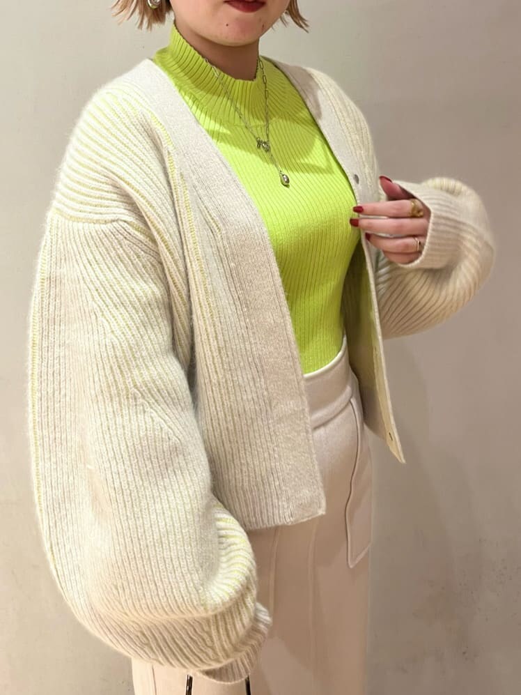 ブラウン系のブーツ、ベージュ系のショルダーバッグ、グリーン系のニット/セーターを着用したレディースの秋コーディネートの5枚目の写真