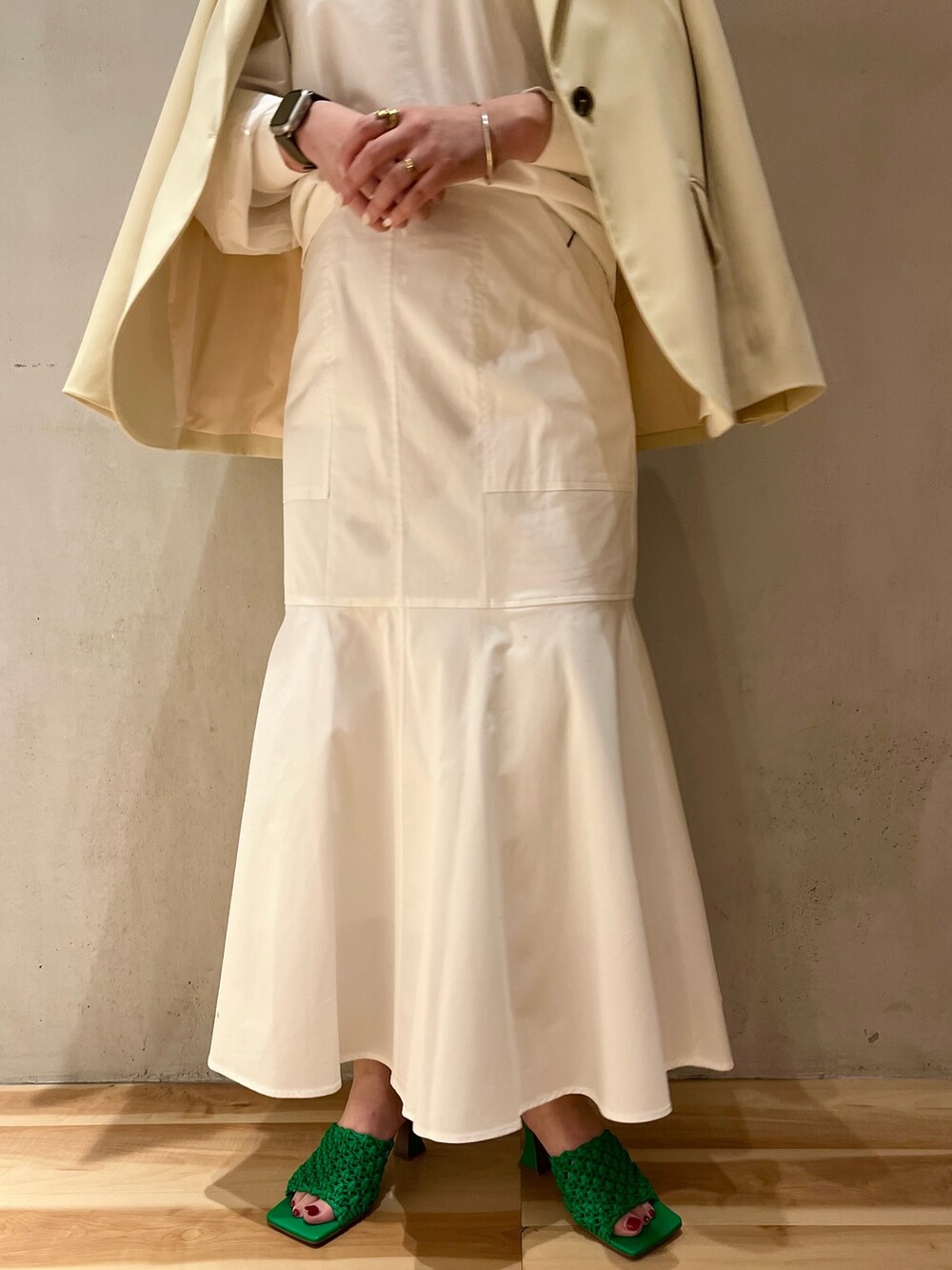 イエロー系のテーラードジャケット、ホワイト系のニット/セーター、ホワイト系のスカートを着用したレディースの冬コーディネートの7枚目の写真