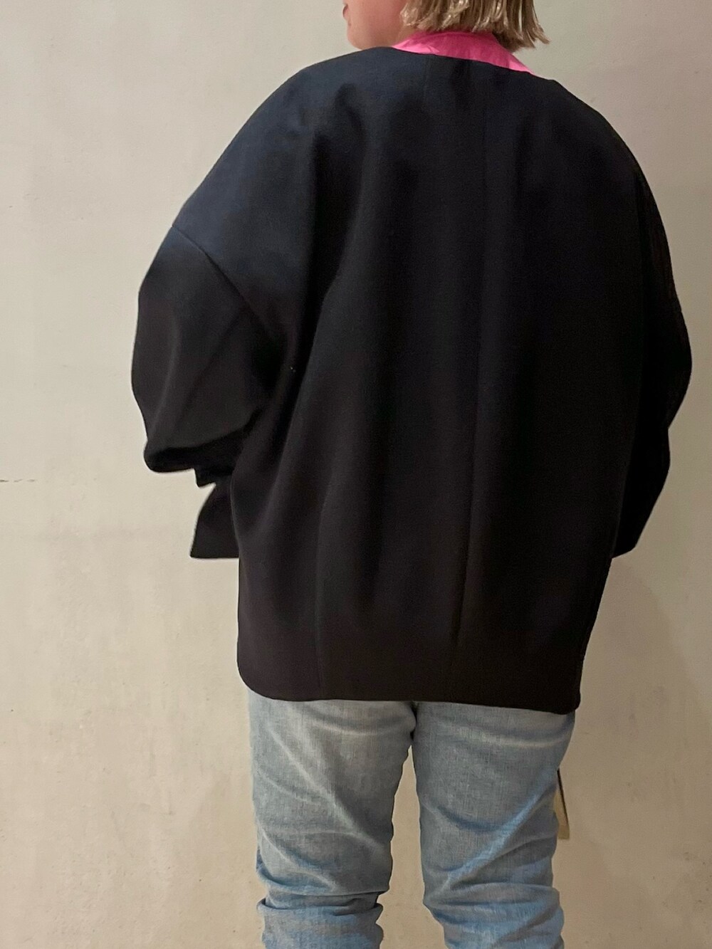 ピンク系のニット/セーター、ブラック系のステンカラーコート、ベージュ系のショルダーバッグを着用したレディースの冬コーディネートの4枚目の写真