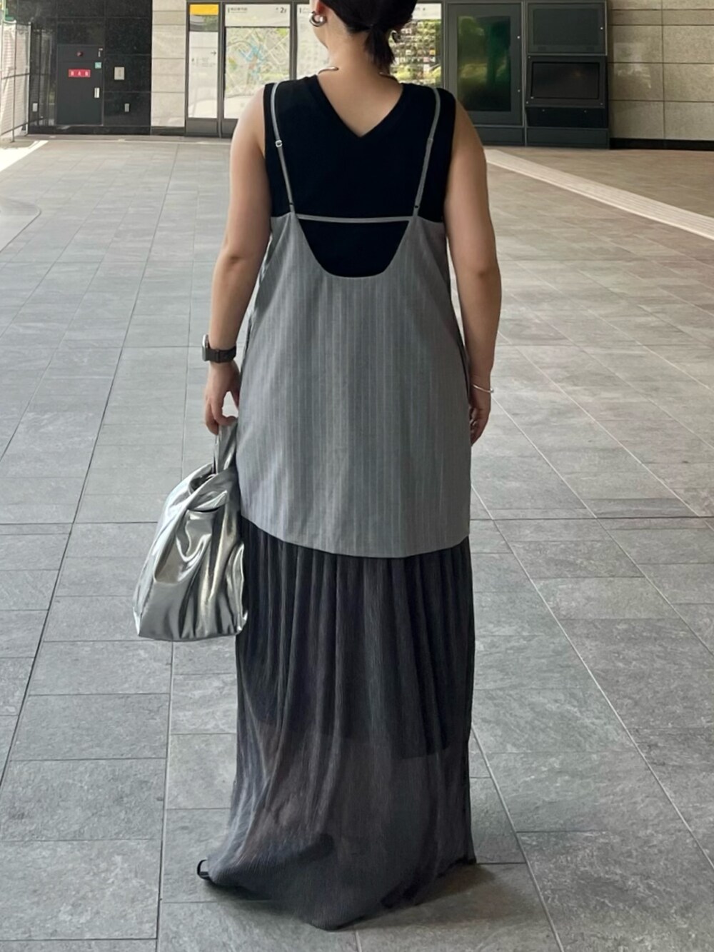 ブラック系のニット/セーター、グレー系のワンピース、シルバー系のハンドバッグを着用したレディースの夏コーディネートの4枚目の写真