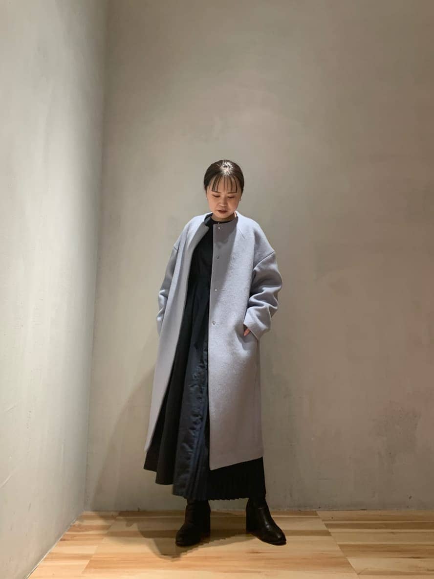 ブラック系のワンピース、ブルー系のノーカラーコートを着用したレディースの秋コーディネートの3枚目の写真