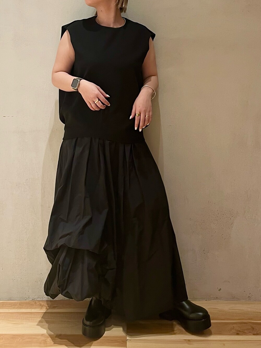 ブラック系のワンピース、ブラック系のブーツを着用したレディースの春コーディネートの4枚目の写真