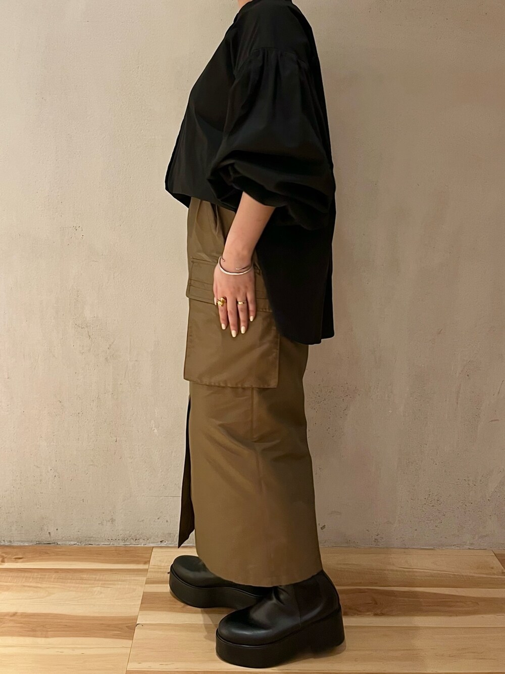 ブラック系のシャツ/ブラウス、ブラウン系のスカート、ブラック系のブーツを着用したレディースの春コーディネートの2枚目の写真