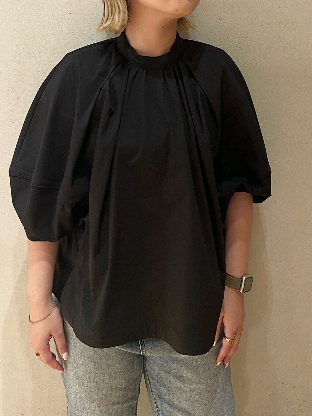 ブラック系のブルゾン、グリーン系のタンクトップ、ブルー系のデニムパンツを着用したレディースの夏コーディネートの6枚目の写真