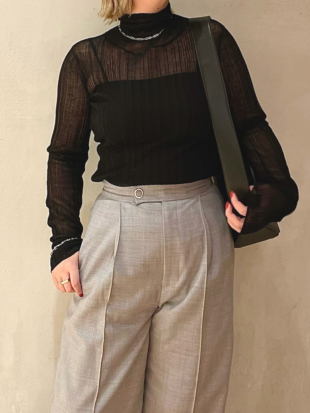 ブラック系のニット/セーター、グレー系のその他パンツ、ブラック系のショルダーバッグを着用したレディースの秋コーディネートの4枚目の写真