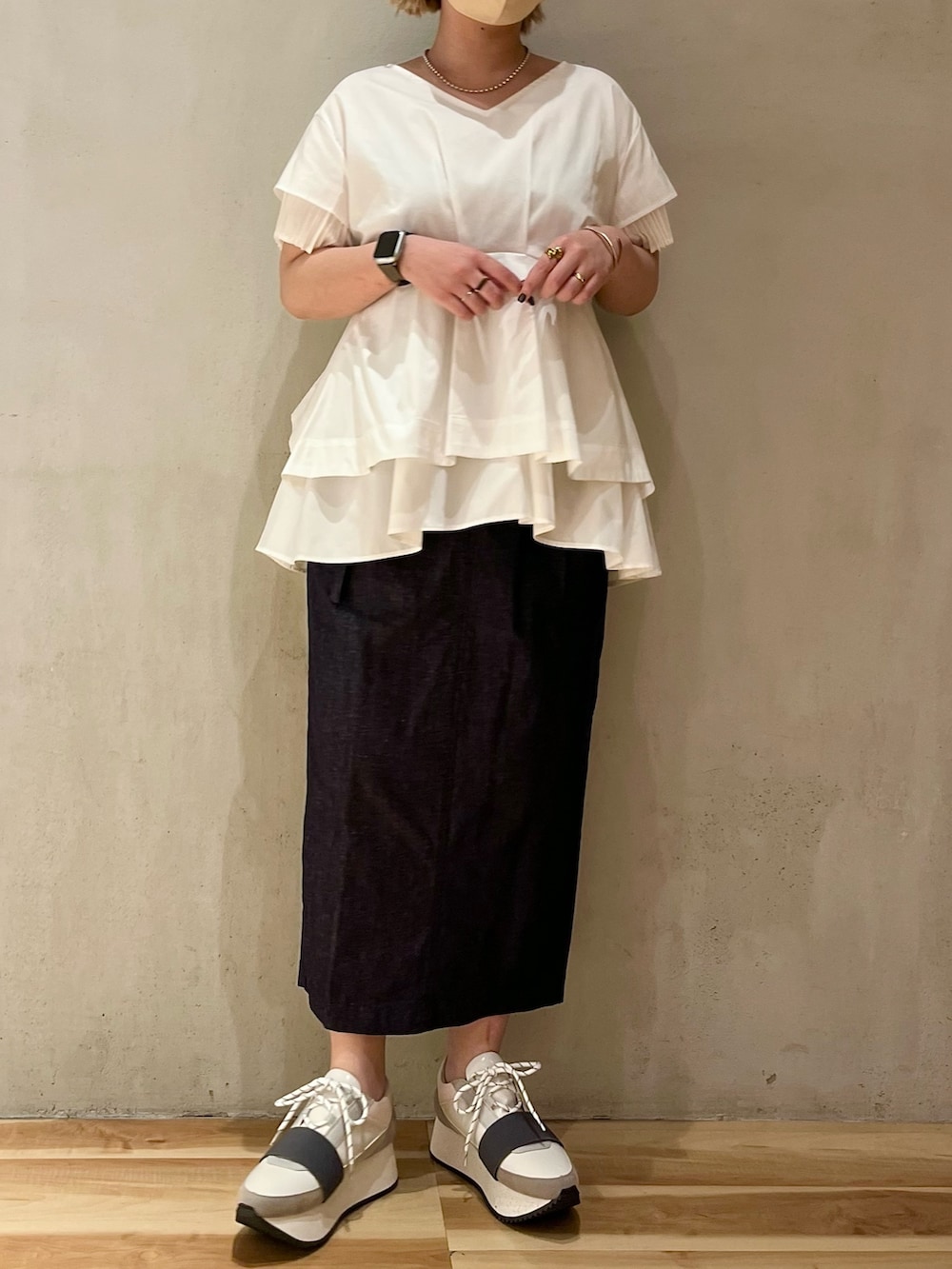 ホワイト系のシャツ/ブラウス、ブルー系のスカート、グレー系のスニーカーを着用したレディースの春コーディネートの2枚目の写真