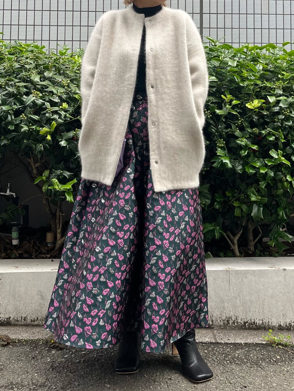 ホワイト系のノーカラージャケット、グリーン系のスカート、ブラック系のブーツを着用したレディースの夏コーディネートの4枚目の写真