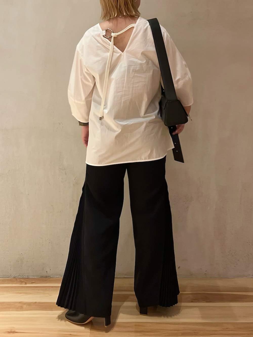 ホワイト系のシャツ/ブラウス、ブラック系のその他パンツ、ブラック系のブーツを着用したレディースの夏コーディネートの3枚目の写真