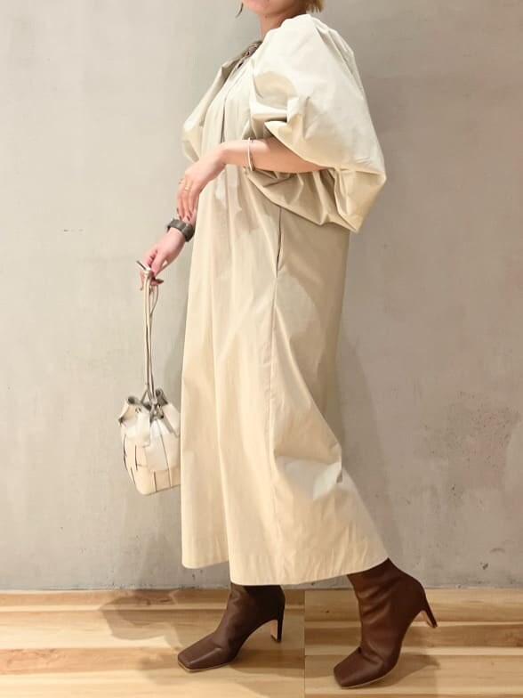 ベージュ系のワンピース、ブラウン系のブーツを着用したレディースの夏コーディネートの2枚目の写真