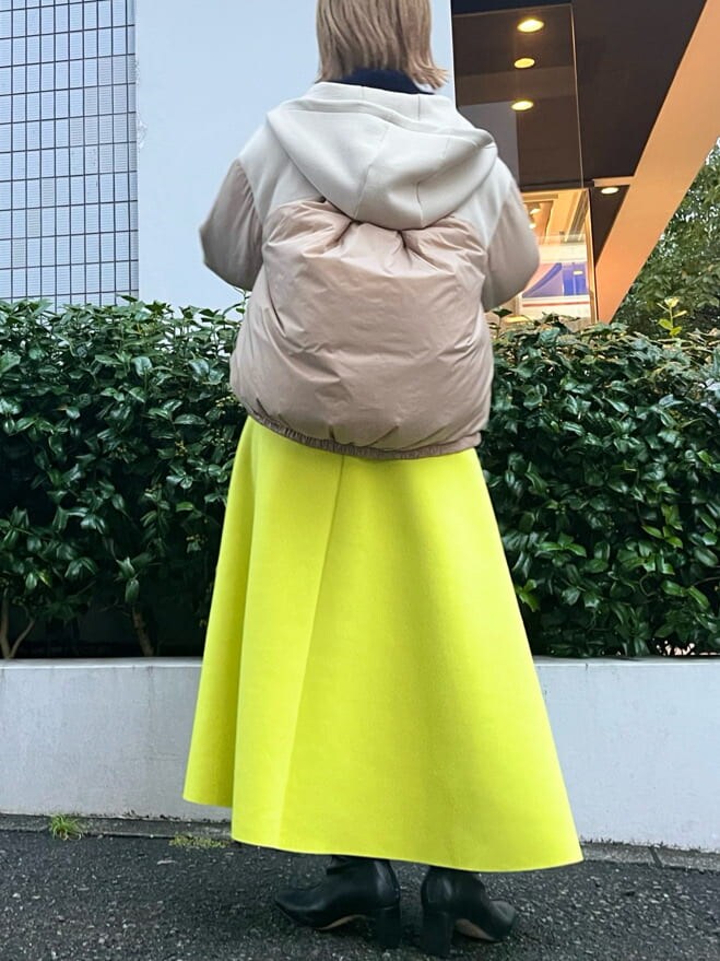 ベージュ系のダウンジャケット/コート、ブルー系のニット/セーター、イエロー系のスカートを着用したレディースの秋コーディネートの3枚目の写真