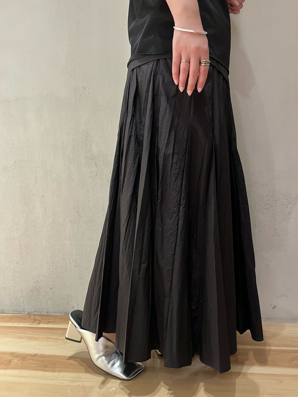 ブラック系のシャツ/ブラウス、ブラック系のスカート、シルバー系のパンプスを着用したレディースの夏コーディネートの8枚目の写真