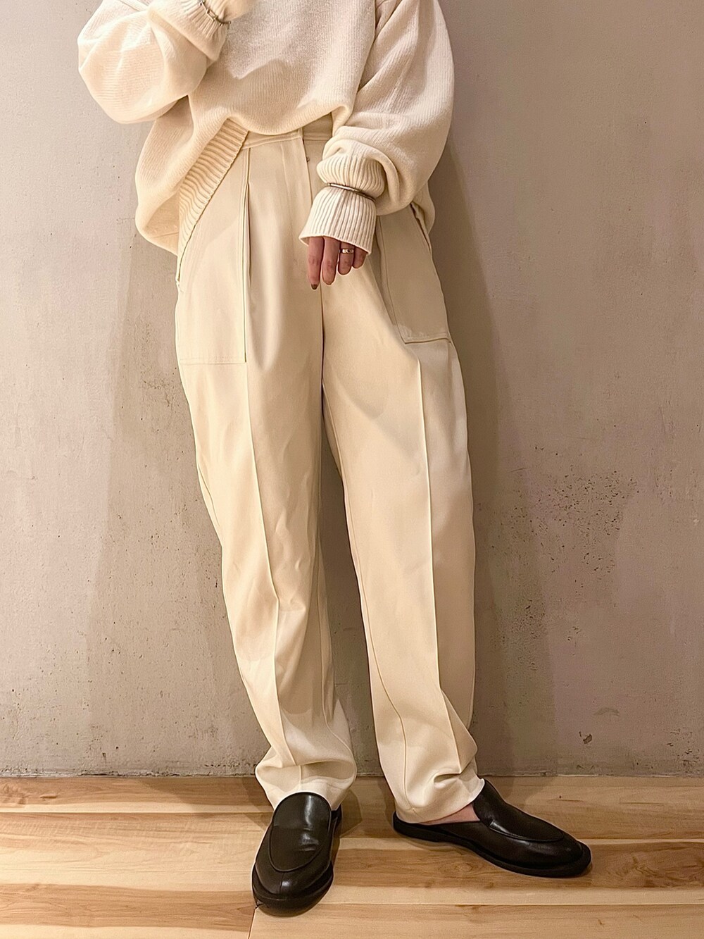 ホワイト系のニット/セーター、ホワイト系のその他パンツ、ブラック系のハンドバッグを着用したレディースの夏コーディネートの6枚目の写真