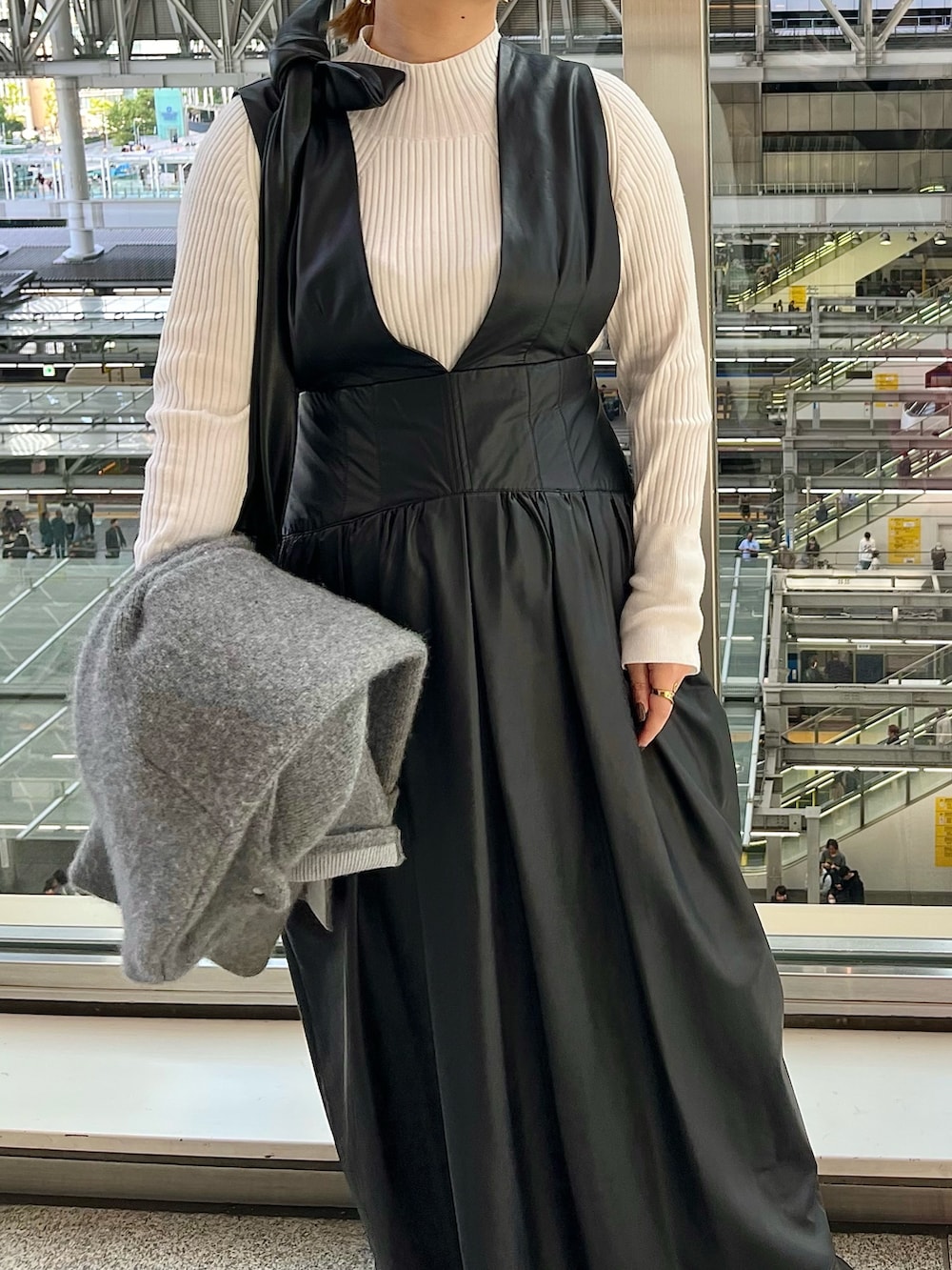 グレー系のノーカラージャケット、ブラック系のジャンパースカート、ホワイト系のニット/セーターを着用したレディースの秋コーディネートの8枚目の写真