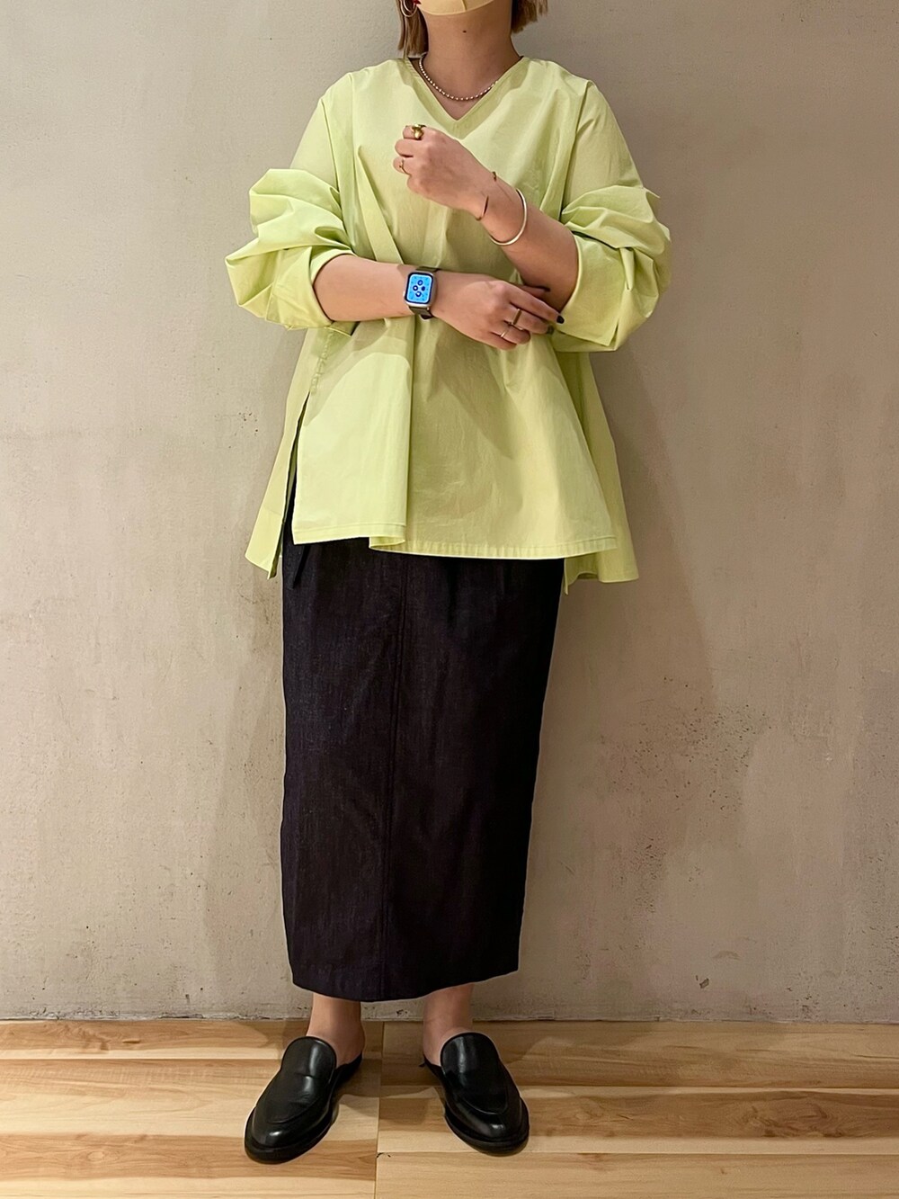 イエロー系のシャツ/ブラウス、ブルー系のスカート、シルバー系のネックレスを着用したレディースの春コーディネートの4枚目の写真