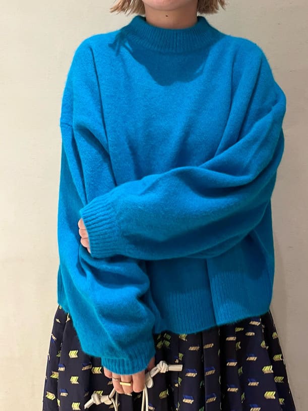 ブラック系のブーツ、ブルー系のスカート、ブルー系のニット/セーターを着用したレディースの秋コーディネートの5枚目の写真