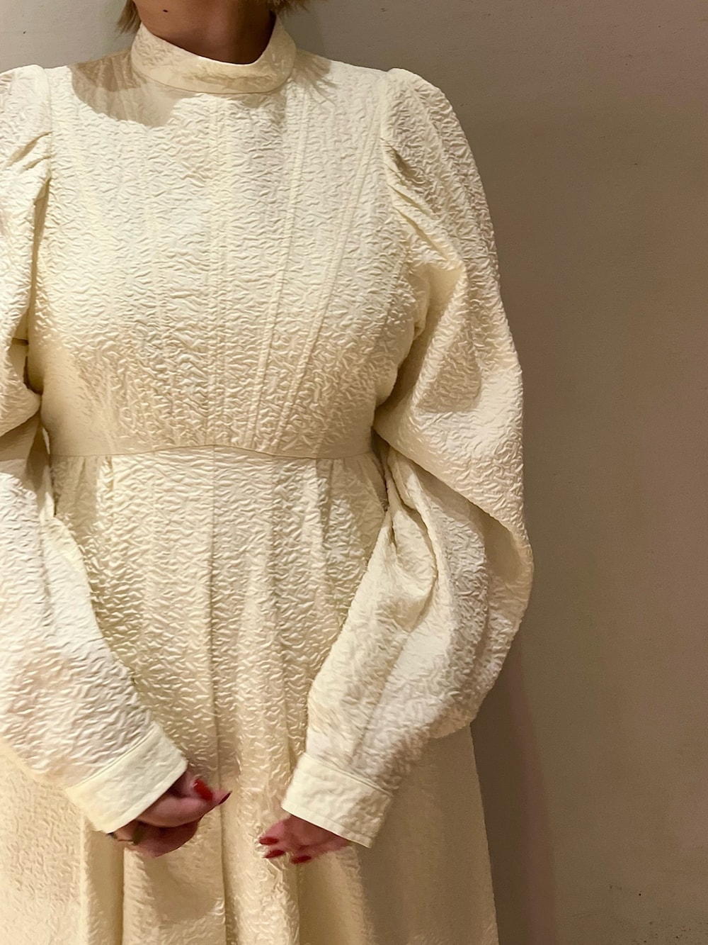 ホワイト系のノーカラージャケット、ホワイト系のワンピース、ベージュ系のブーツを着用したレディースの秋コーディネートの8枚目の写真