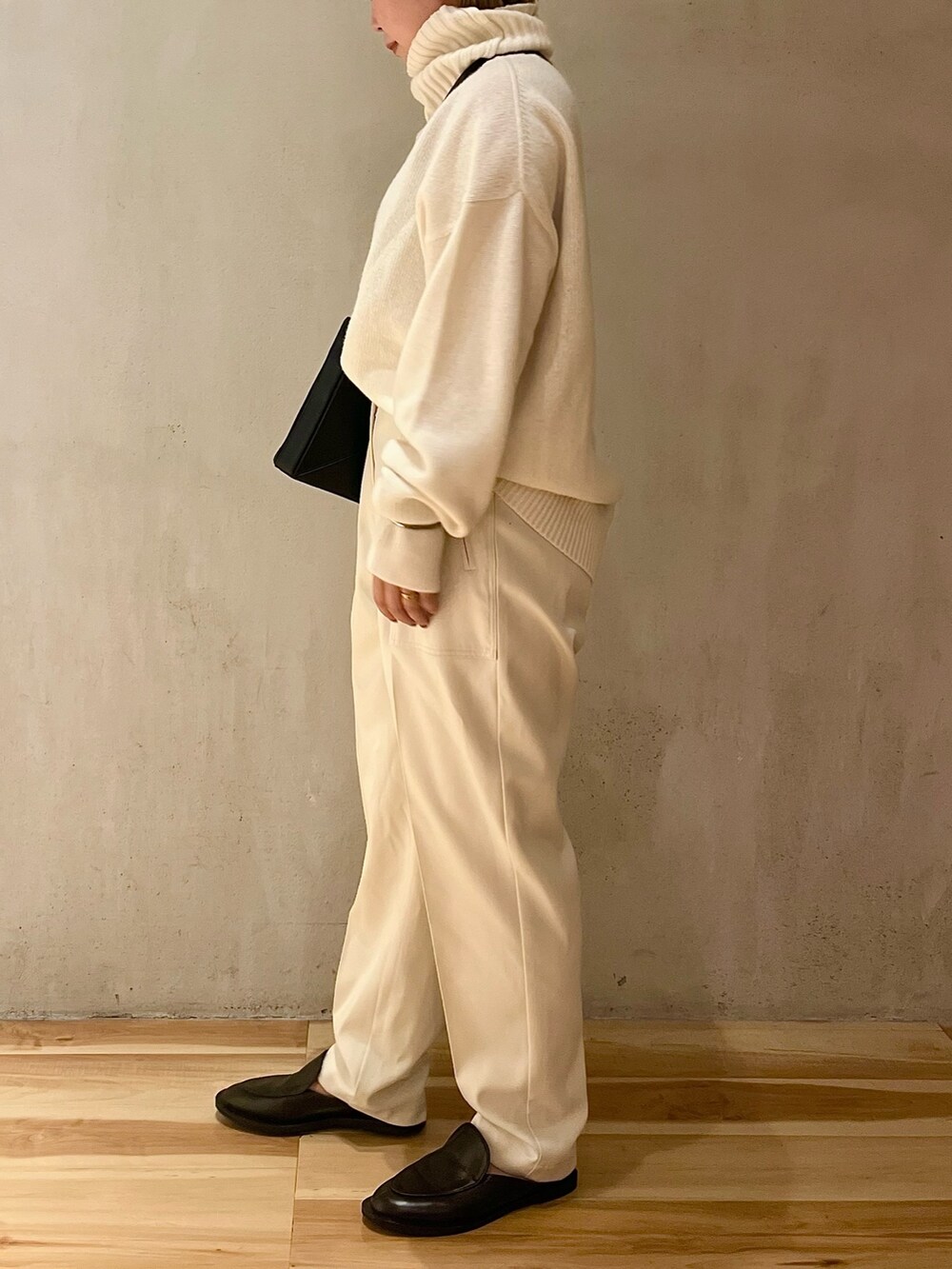 ホワイト系のニット/セーター、ホワイト系のその他パンツ、ブラック系のハンドバッグを着用したレディースの夏コーディネートの4枚目の写真