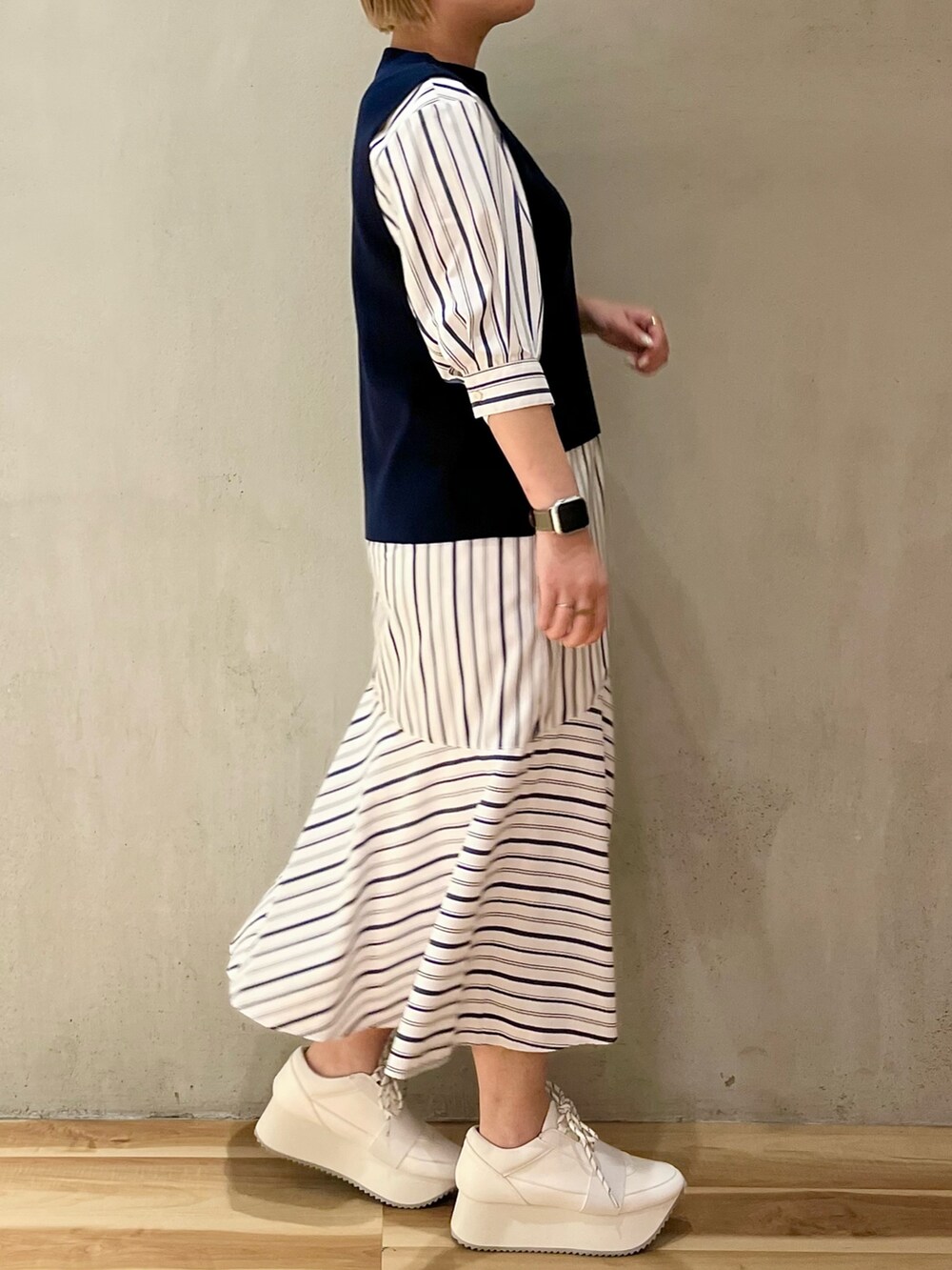 ホワイト系のスニーカー、ブルー系のワンピースを着用したレディースの冬コーディネートの2枚目の写真