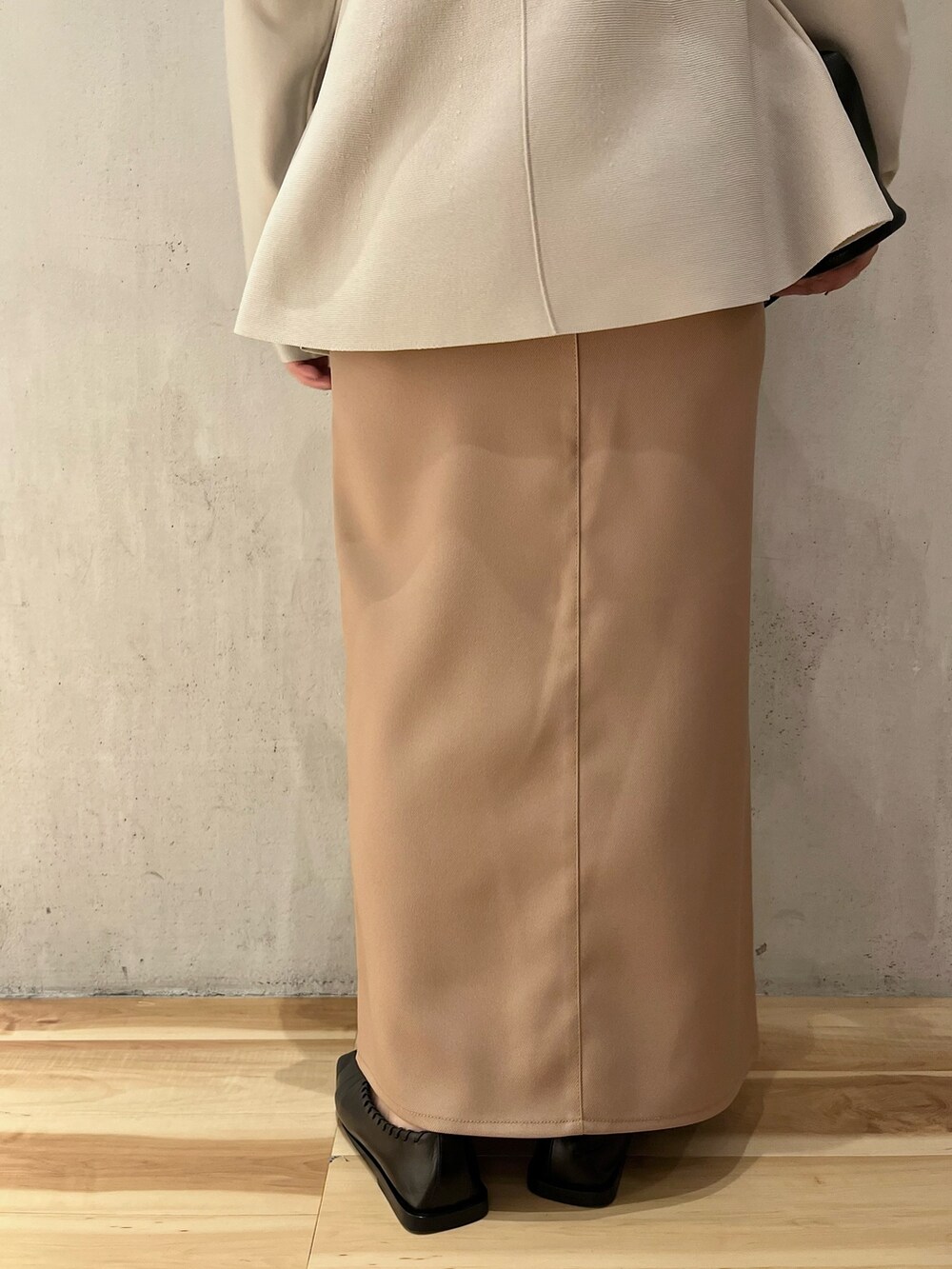 グレー系のニット/セーター、ベージュ系のスカートを着用したレディースの冬コーディネートの6枚目の写真