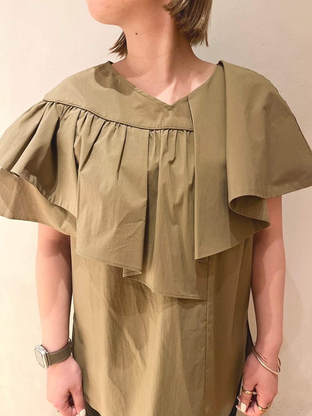 グリーン系のシャツ/ブラウス、ブラック系のスカート、ブラック系のサンダルを着用したレディースの冬コーディネートの7枚目の写真